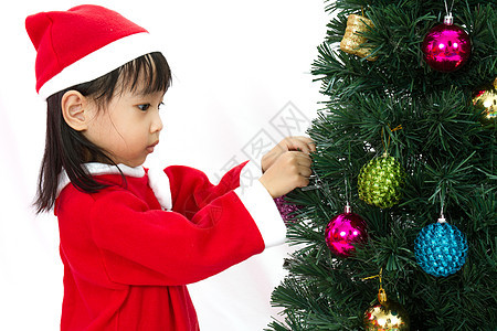 亚裔中国小女孩摆着圣诞树的装扮 快乐的 礼物 快乐图片
