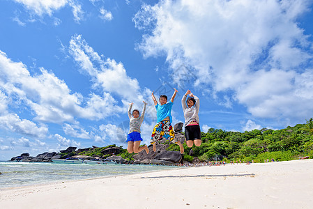 幸福的家庭在泰国海滩上跳跃 海洋 青少年 岛 云图片