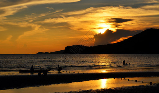 在海滩与人们共度的日落时图片