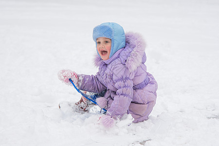 快乐的小女孩滑下冰冷的山丘 愉快地看着其他孩子图片