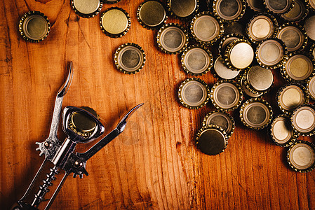 古老的瓶装开瓶器和一堆啤酒瓶盖 铝 经典的 闪亮的图片