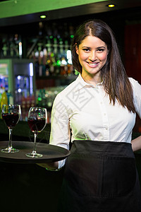 漂亮的女服务员为红酒服务的肖像图片