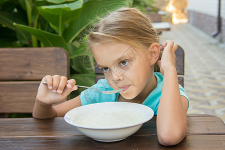 六岁烦躁的六岁女孩 慢慢吃粥当早餐图片