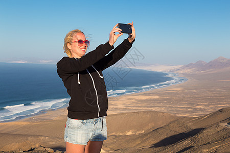 在El Cofete海滩拍假自拍的女人 山脉图片