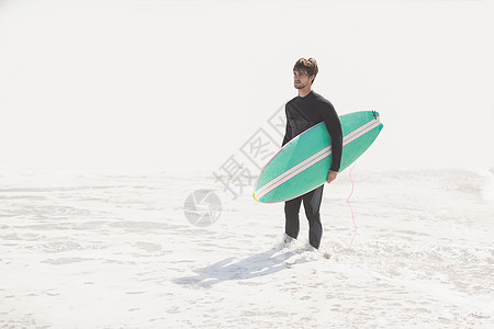一个人在海滩上拿着冲浪板 海浪 户外 阳光 闲暇背景图片
