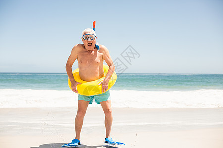 沙滩上带游泳戒指和拖鞋的老人 快乐 自由 波浪图片