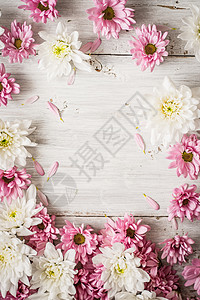 白色木制桌垂直的粉红花和白花边框图片
