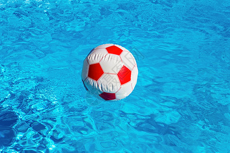 蓝游泳池中漂浮的海滩球图片