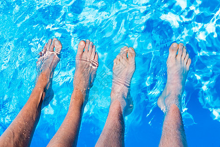 在游泳池水中四只赤脚图片