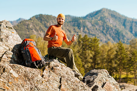 留着胡须的年轻男性正在穿越山区 旅游背包站在岩石山上 同时欣赏自然景观 在山区度过暑假 旅行 宁静图片