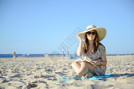 在海滩上轻松放松 读着一副BO的黑发美女肖像 夏天 阳光图片