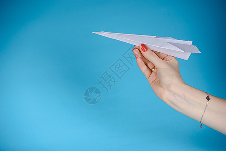 纸平面 蓝色背景 手指 航班 玩具 商业 蓝色的图片