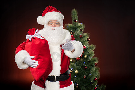 红麻袋圣诞老人 解雇 尼古拉斯 快乐的 打手势 圣诞帽 礼物图片