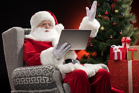 使用笔记本电脑和探险的圣诞老人 快活的 圣诞节的时候 新年图片
