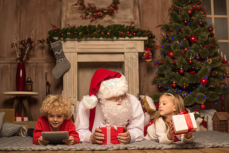 圣诞老人和孩子们躺在地毯上 打手势 快乐的 享受 圣诞节图片