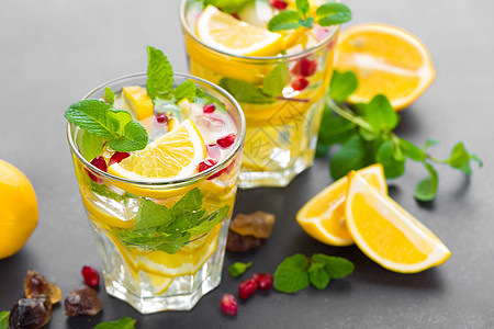 果肉果汁柠檬莫吉托鸡尾酒 配有新鲜薄荷和石榴 冷清凉的夏季饮料或冰饮料 派对 喝背景