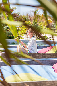 女士看书和在热带雨林花园放松的光彩照人 水图片