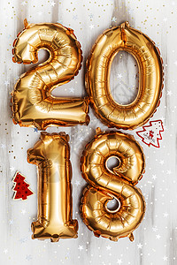 明亮的金属金色气球代表 2018 年 圣诞节 新年气球 白色木桌背景上闪闪发光的星星 派对 金的图片