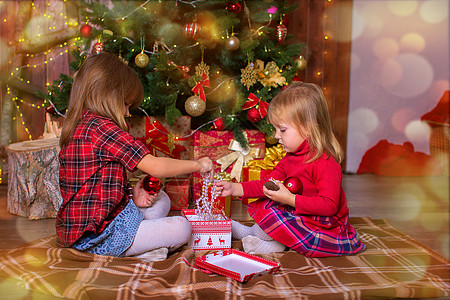 姐妹姊妹的姑娘们在圣诞树下送礼物图片