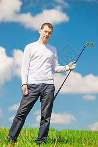 在绿色田地上装着球和高尔夫球的男子图片
