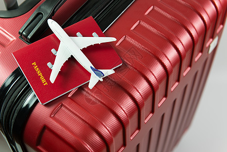 红色行李上的红色护照和飞机模型 红色的 飞机场 手提箱图片
