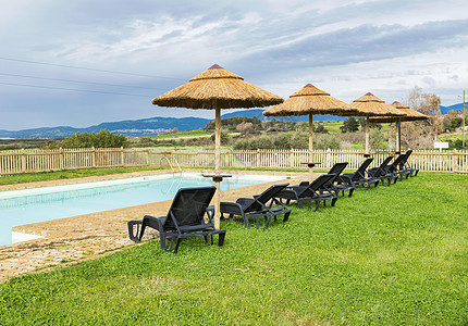 带阳伞和椅子的游泳池 水池 甲板 奢华 天空 躺椅图片