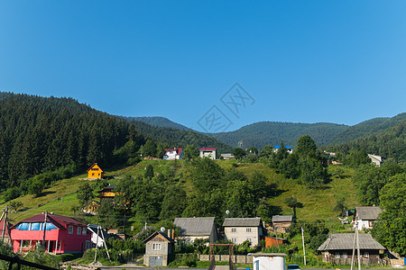 山上云杉林背景下山上有大房子的喀尔巴阡村庄图片