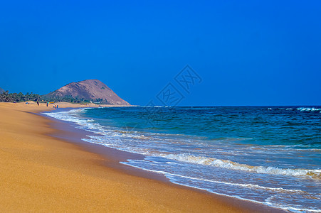 狂野空旷的热带海滩 充满活力的黄沙 明亮的蓝天 清澈的海水 白天阳光明媚的日子里 水在岸上撞击 海滨 支撑图片