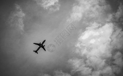 国际航空公司在乘坐灰色天空和白云起飞后出现的黑色和白色景象 高的图片