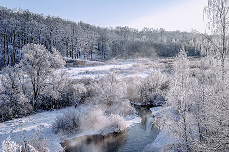 充满河流和森林的寒冬阳光明媚的风景 覆盖 雪图片