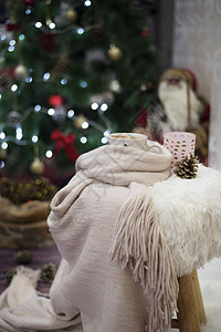 热巧克力 一杯卡布奇诺 在一棵大圣诞树前的毛皮椅子上 带球和灯光的火辣果 冬天 圣诞快乐图片