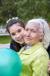 可爱的十几岁女孩拥抱着她美丽的笑脸外婆图片