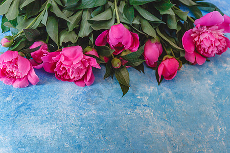 在蓝色大理石雕像上的花瓶里 装着粉红色纯绿色的花束 夏天 礼物图片