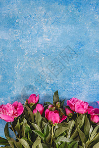 在蓝色大理石雕像上的花瓶里 装着粉红色纯绿色的花束 夏天 自然图片