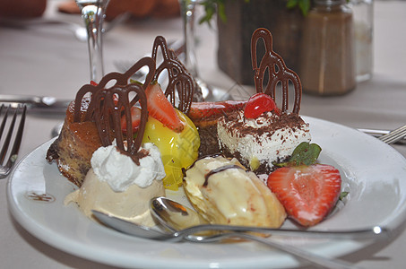 餐桌上有很多不同的蛋糕 上面有奶油和水果摊子 在饭店餐厅吃早餐图片