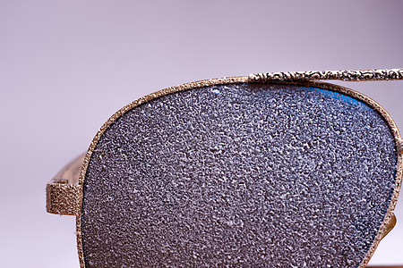 白棕色背景的近视镜上有人造雪的太阳镜 覆盖背景图片