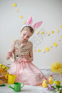 可爱的小女孩 用兔子耳朵画鸡蛋 复活节装饰图片