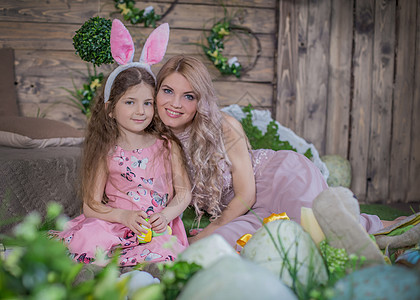 身着兔子耳朵的小女孩和母亲在复活节中图片