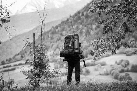 一个带背包的徒步旅行者 看着距离 黑与白 远足背景图片