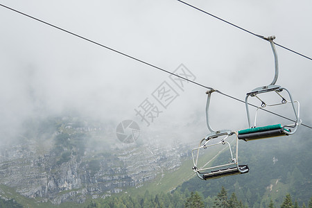 背着山和雾的椅子起吊车 滑雪板 爬坡道 单板滑雪 滑雪者 滑雪缆车图片