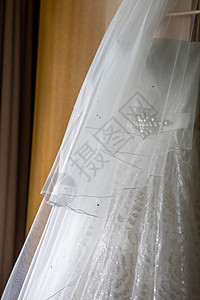 挂在木制衣柜上的新娘礼服 衣架 丝绸 连衣裙图片