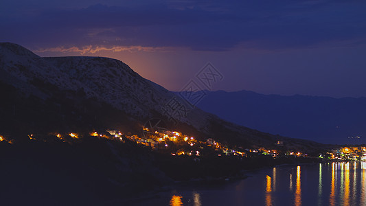 月光下的夜景从克罗地亚的岩石山到亚得里亚海沿岸的城市 不同的色调 游客 海滩图片