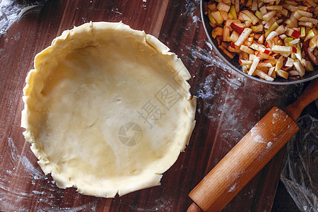 烹饪过程 室内美式苹果派 深色木质背景上配有脆皮糕点 滚生面团 从上面看 复制空间 平躺 厨房 馅饼图片