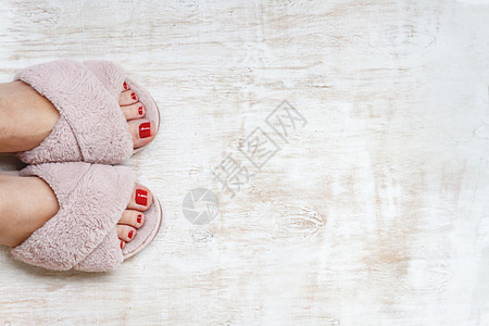 双脚和红指甲 在家庭毛毛 毛毛的粉红色拖鞋上 时尚 凉鞋图片