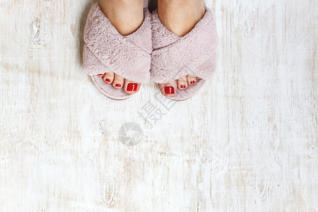 双脚和红指甲 在家庭毛毛 毛毛的粉红色拖鞋上 衣服 凉鞋图片