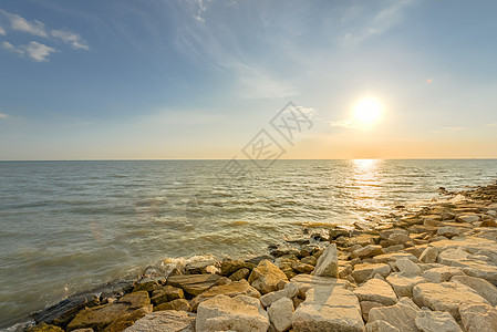 在梅拉卡 长堤断墙海岸线和水平日落 晴天 橙子背景图片