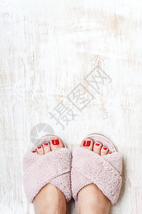 双脚和红指甲 在家庭毛毛 毛毛的粉红色拖鞋上 凉鞋 修脚图片
