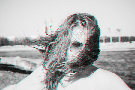 一个戴墨镜的年轻女孩笑着 她的头发遮住了脸 风 Effekt 故障浮雕 黑白单色 复古照片图片