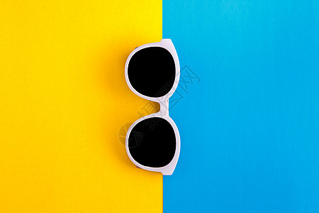 时尚的白色太阳镜在明亮蓝色和黄黄色背景上 顶部视图 孤立 复制空间 海滩图片