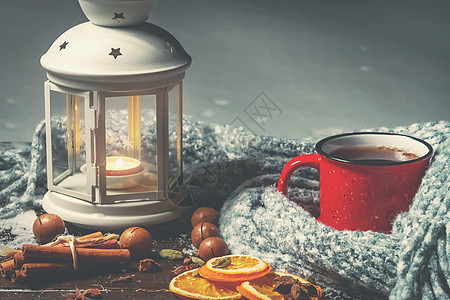 灯笼 有烧着的蜡烛 香料和红杯子 在雪地木板上加热咖啡 围巾 火焰图片